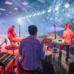 Groupe afrobeat jouant sur scène devant un public éclairé