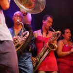 Musiciens jouant des cuivres et une clarinette sur scène