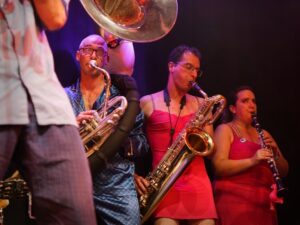 Musiciens jouant des cuivres et une clarinette sur scène