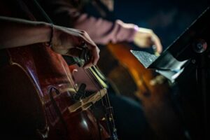 Gros plan sur un violoncelle joué au sein d’un ensemble musical